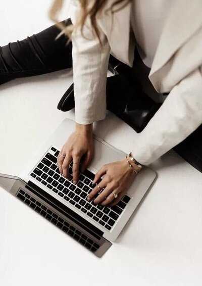 Woman sitting on the floor typing on a laptop