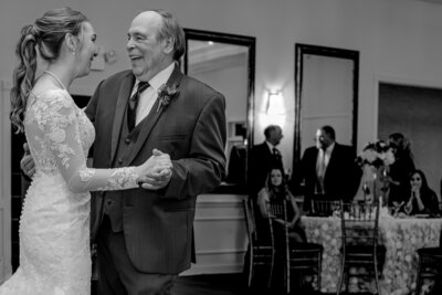 A smiling dad dancing with his daughter on her wedding day at The Hudson Manor enjoying their Raleigh wedding photography session with JoLynn Photography