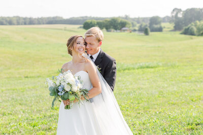 Virginia bride and groom standing in front of their wedding venue, the White Oak Manor on their wedding day