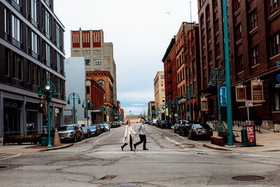 A couple walking across the street holding hands in downtown Milwaukee