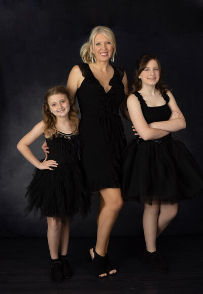 mom-and-daughters-posing-in-studio-rlington-with -black-dresses-and-black-backdrop