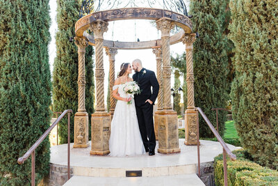 bride and groom looking into each others eyes under gazebo