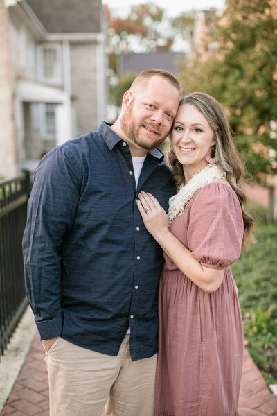 husband and wife outdoor downtown with greenery portrait looking at the camera