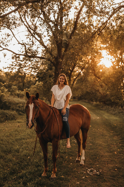 Senior on horse with sunsetting in the back