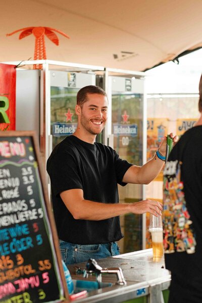 Lachende bartender tijdens een Indisch festival in amsterdam