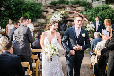 Bride and Groom Walk Up Aisle after outdoor wedding at Phipps Conservatory