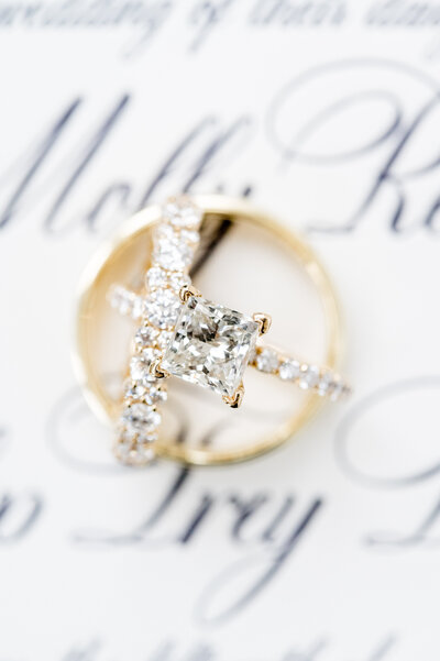Close up of wedding rings on wedding invitation.