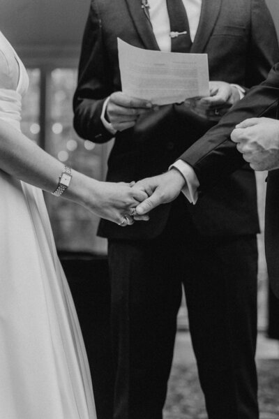 black and white image bride and groom holding hands