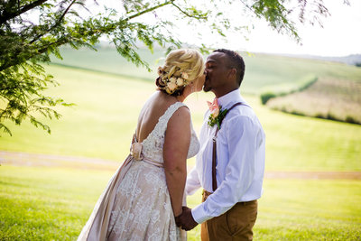 Bride and groom kiss under a tree at their Betsy's Barn wedding