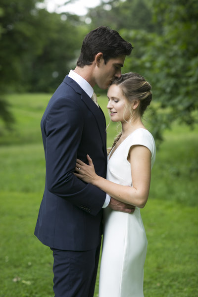 Bride and groom kiss in field at Awbury Arboretum Wedding
