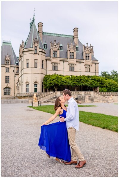 couple kissing with blue dress  in the back of Biltmore Estate