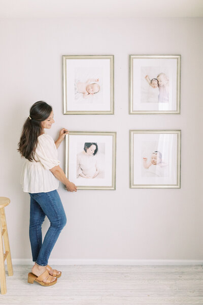 photo of Talia Laird Photography holding framed fine art prints that she custom framed for her Milwaukee newborn photography clients