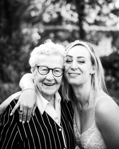 A bride and her grandmother pose in a black and white photo for their portraits after the ceremony