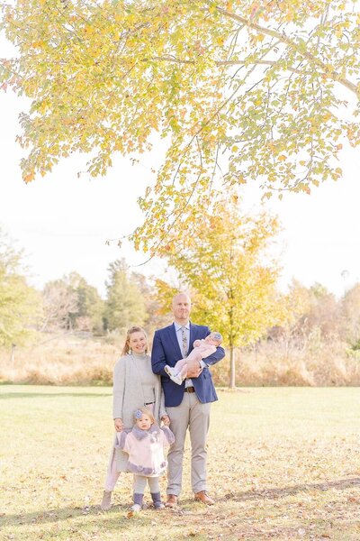 family posing for pictures during fall mini session in Sterling, VA