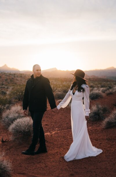 Adorable couple strolling hand in hand, exchanging loving gazes amid their Las Vegas elopement at Valley of Fire.