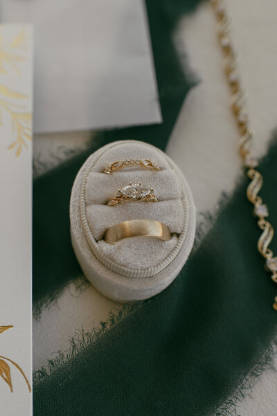 Wedding ring set in a velvet box with invitations.
