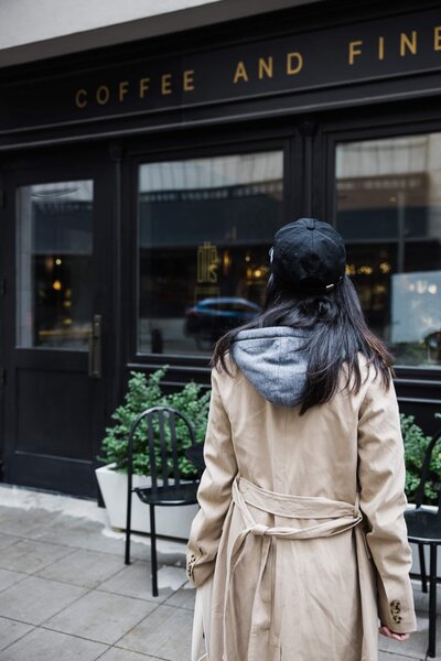 A woman holding a drink while reading a book. Showing that with anxiety therapy in Manhattan you can calm the inner chaos. An anxiety therapist can help you learn to relax and enjoy every day.