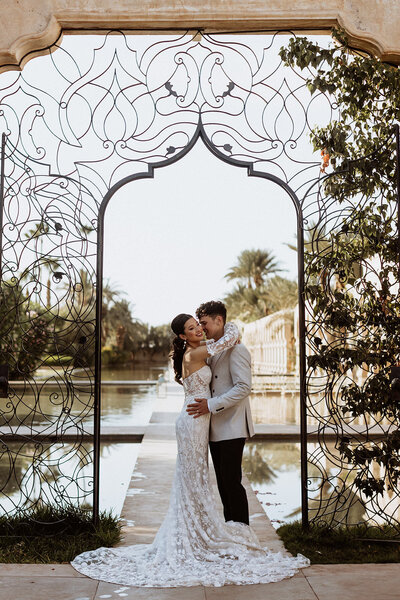 bride and groom stand in arch in Palais Namaskar