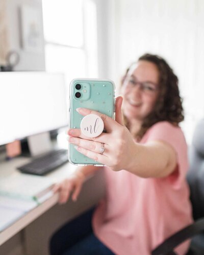 Online marketer posing for Nashville branding photos with a green Iphone and a custom logo popsocket