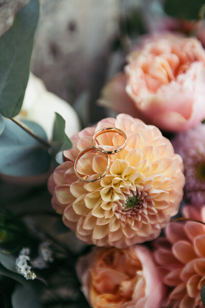 Close-up of wedding bands delicately placed on vibrant flowers, capturing the symbolic beauty of commitment and love