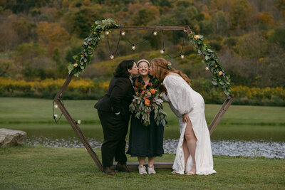 LGBTQ wedding photographer posese with 2 brides