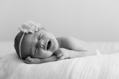Newborn baby girl smiling with a headband on