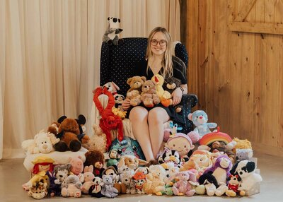 Maddie Rae Photography Maddie sitting in a chair with a bunch of stuffed animals she collected from her first mini give back event