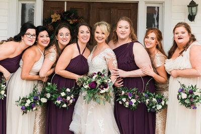 Bridesmaids holding hoop bouquets in front of main house at Grace Valley Farms