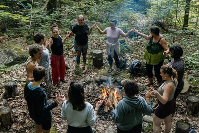 group of women circled around a campfire at a wellness retreat