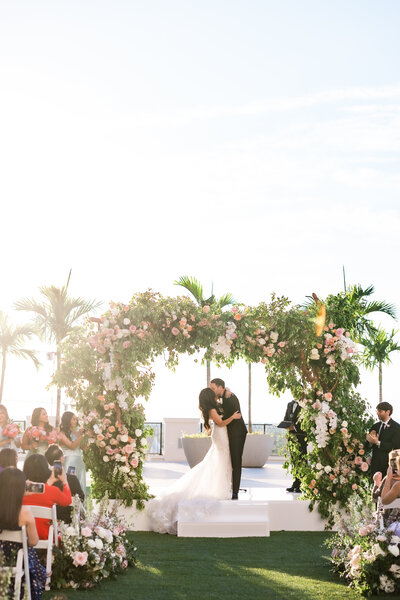 A bride and groom portrait with the bride and groom sharing their first kiss at the Loews Coral Gables by south Florida wedding photographer Angelika Krug Photo & Film