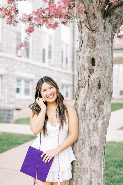 A senior girl wearing a white dress gets her photos taken at James Madison  University. Taken by Harrisonburg  Senior photographer, Rachel Jordan Photography.