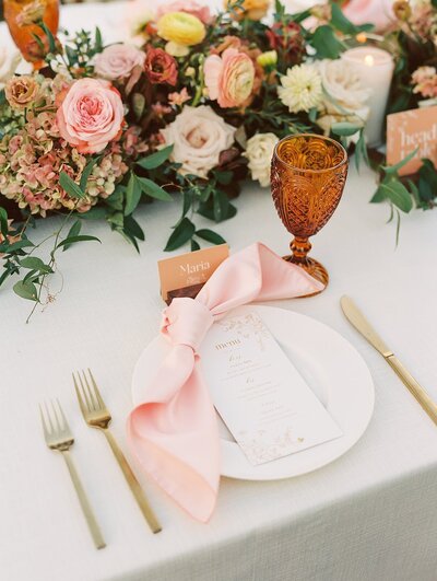 Table setting with gold flatware and colorful florals