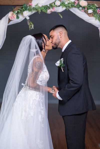 Emotional first kiss of a beautiful black couple at their wedding ceremony in our indoor Clearwater event venue - A moment of love and joy
