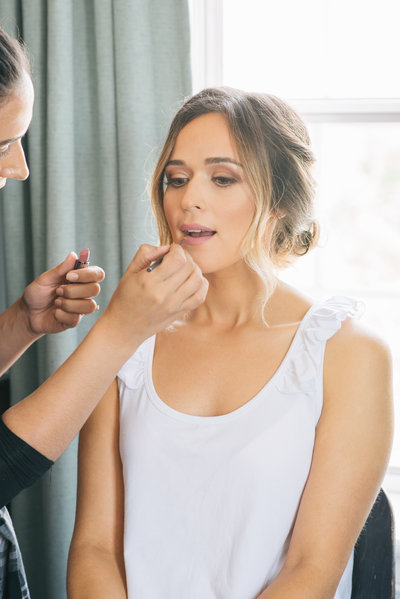 Bride getting professional makeup applied on her wedding day
