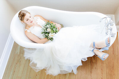 A bride sits in the tub in the Kendall Point bridal suite.