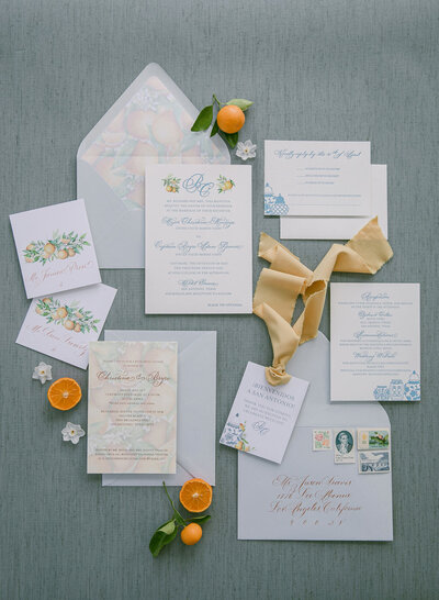 Custom wedding invitation suite featuring blue letterpress printing and full color digital printing with citrus elements and envelope liner as well as copper envelope mailing address calligraphy