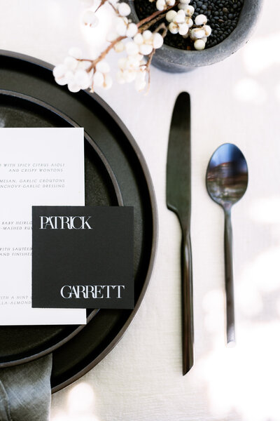 Black and white place setting on wedding reception table