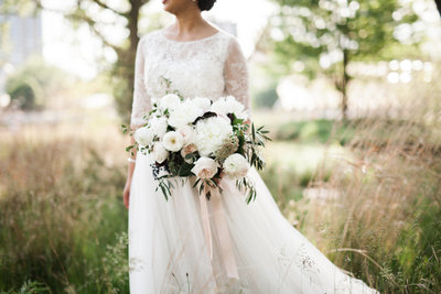 Bride with garden style bouquet in field.