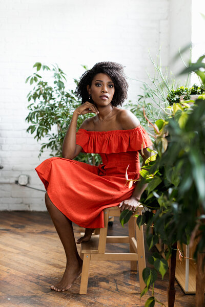 black woman with red dress and plants