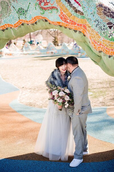 Couple snuggled together under the dragon at Fannie Mae Park in Nashville after their elopement