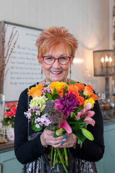 Jane Shine with bouquet of colorful flowers