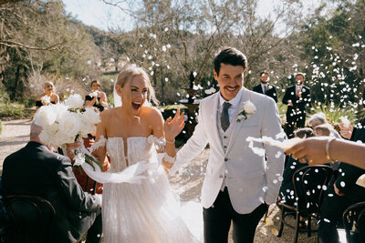 Jas & Brett walking down the aisle with confetti at their wedding at Redleaf Wollombi in the Hunter Valley
