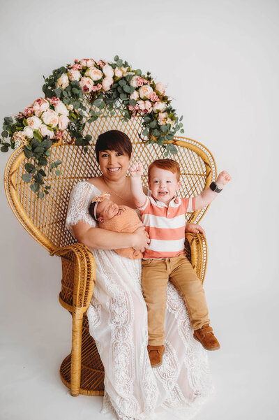 Mother poses with her children during a Newborn  Photoshoot in Asheville Photo Studio.