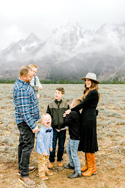 Photo of Family in a field with Mountains in Background in Grand TEton National Park with Anna Christine Photography