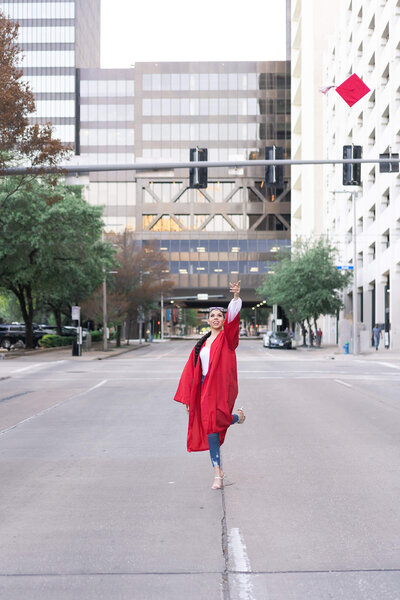high school senior tosses cap in the air in downtown Houston Texas by Swish and Click Photography