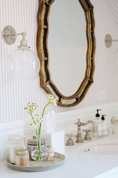 little girls pink and white bathroom with striped wallpaper gold ornate mirrors and victorian faucets and accessories