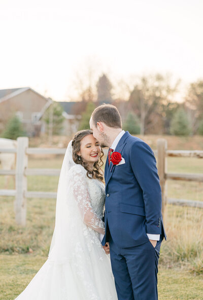 In a captivating outdoor wedding at the Sycamore Venue, the bride tenderly caresses the groom's cheek, a portrait capturing the essence of love and joy