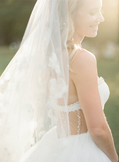 smiling bride in white wedding dress and veil