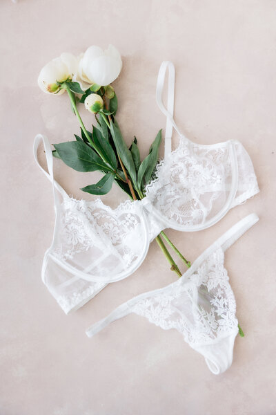 Photo of flowers and lingerie artistically displayed for a bridal boudoir session by Florida boudoir photographer Angelika Krug Photo & Film