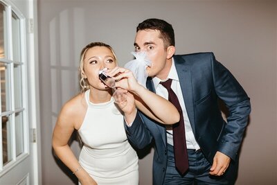 bride and groom drinking champagne in hotel lobby